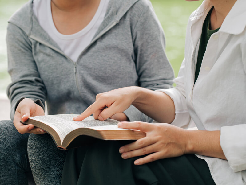 Two Women Studying And Talking About The Bible .
